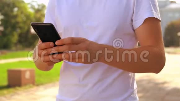在户外使用智能手机的男性手部特写视频的预览图