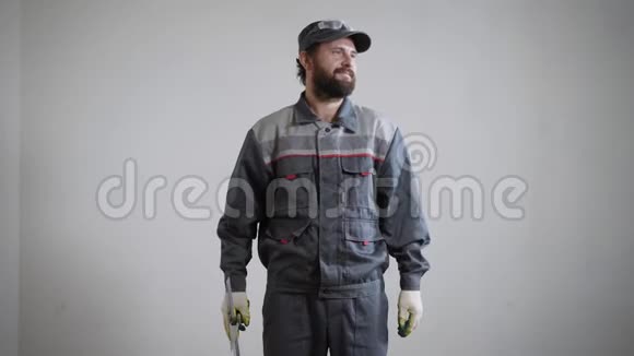 幸福的建筑工人站在墙边一把铲子放在一个公寓里他穿着制服准备上班视频的预览图