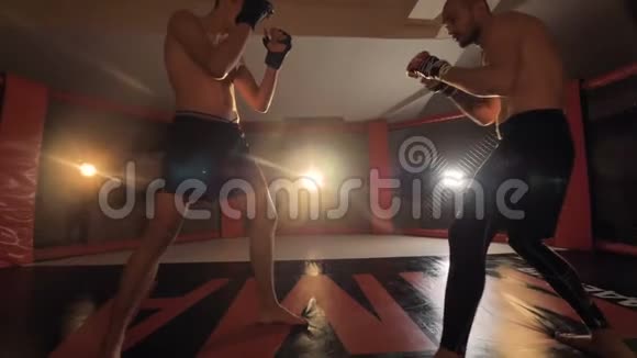 拳击手在击倒对手后将对手扔到一个MMA环地板上4K视频的预览图
