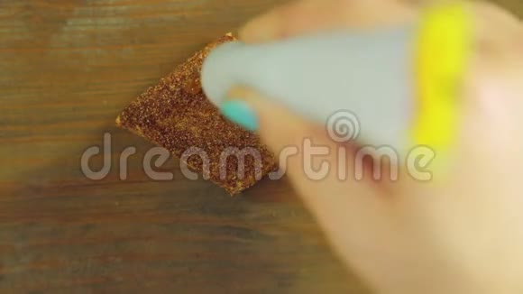 一只手拿着一管烹饪涂料在带有黄色油漆的巧克力饼干上画着滑稽的脸视频的预览图