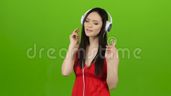 耳机里的女孩听古典音乐绿色屏幕视频的预览图