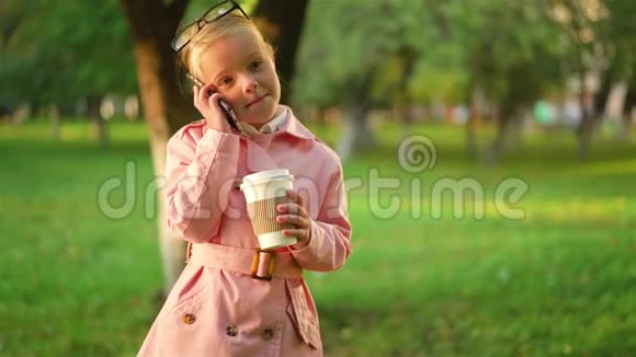 小女孩打电话拿着咖啡视频的预览图