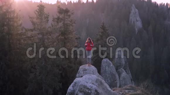 站在悬崖边的女人站在森林背景下视频的预览图