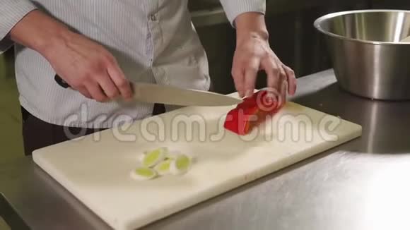 厨师正在餐桌上切一个红色的辣椒作为晚餐视频的预览图