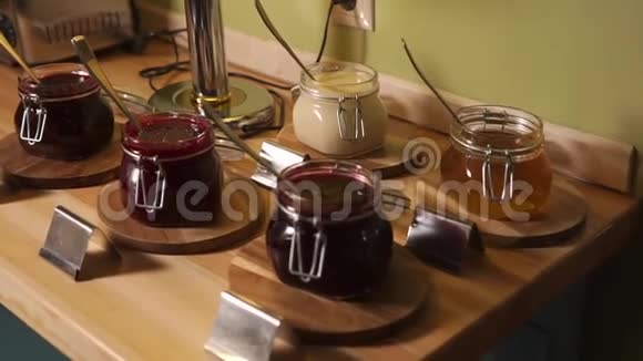 一张桌子上摆着一大堆不同的果酱准备在酒店吃早餐视频的预览图