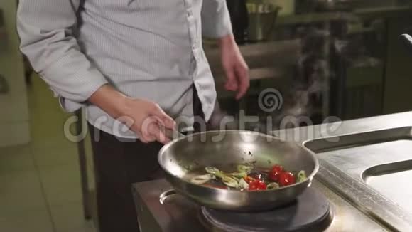 厨师在热炒锅上倾翻蔬菜视频的预览图
