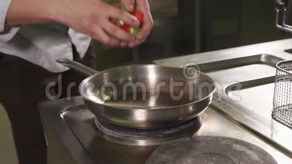 厨师正把切好的辣椒放进热锅里然后把它翻过来视频的预览图