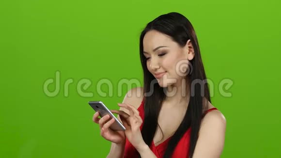 亚洲美女翻过手机照片玩得很开心绿色屏幕视频的预览图
