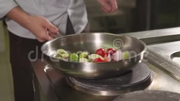 厨师在一个大煎锅上烤蔬菜把它扔掉视频的预览图