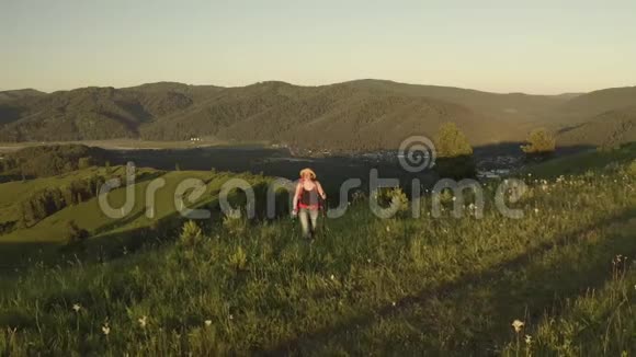 空中近距离女徒步旅行者骄傲地站在山顶年轻女子与背包站在顶部视频的预览图