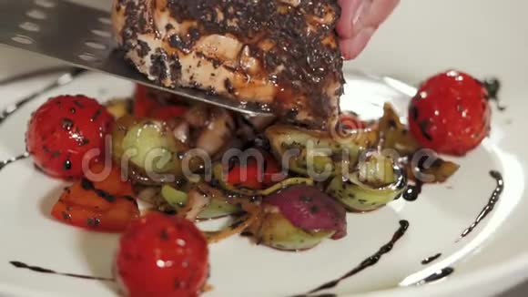 厨师正把一条多汁美味的鱼放在蔬菜垫上视频的预览图