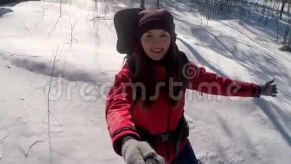 迷人的徒步旅行者在冬天的森林里使用照片相机行走视频的预览图