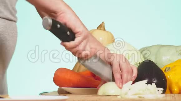 雌手用刀切洋葱蔬菜混合物用于烹饪蔬菜炖背景色4k视频的预览图