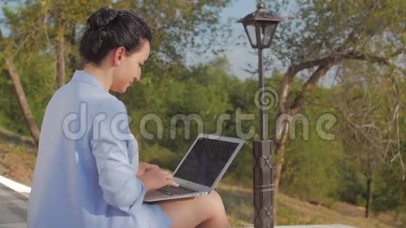 商务女性在手提电脑上工作穿着蓝色西装带手提电脑的漂亮黑发女人漂亮的女士在工作视频的预览图