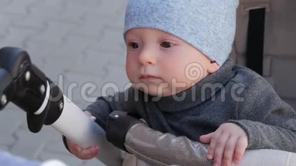 小男孩坐在婴儿车里男孩看着镜头坐在婴儿车里视频的预览图