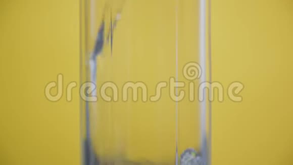 在玻璃黄色背景起泡水中加入气泡的苏打水视频的预览图