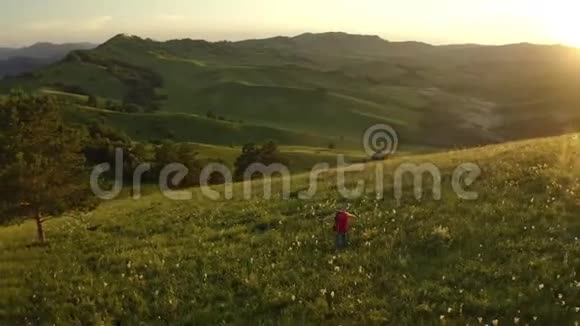 空中近距离女徒步旅行者骄傲地站在山顶年轻女子与背包站在顶部视频的预览图