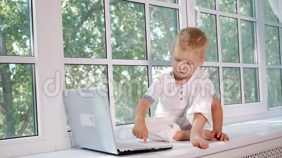 窗台上有笔记本电脑的小男孩视频的预览图