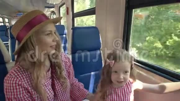 快乐的妈妈和女儿一起旅行上火车看看窗外视频的预览图