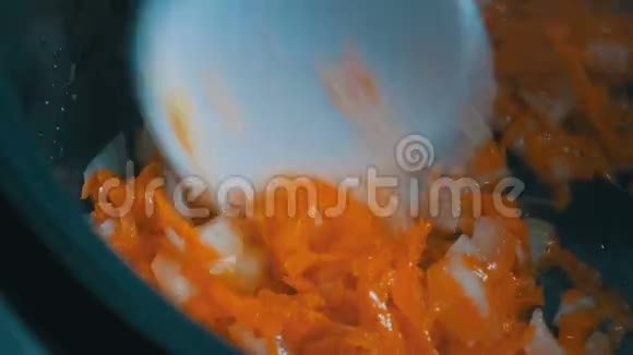 胡萝卜和洋葱用锅烤白色厨房铲搅拌蔬菜素食视频的预览图