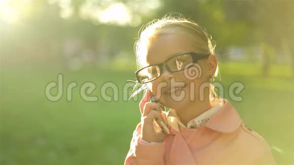 可爱的粉红色小女孩站着打电话视频的预览图