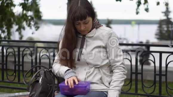 一位年轻女子在阴天在公园拍午餐视频的预览图