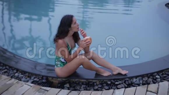 女孩在游泳池附近喝鸡尾酒视频的预览图