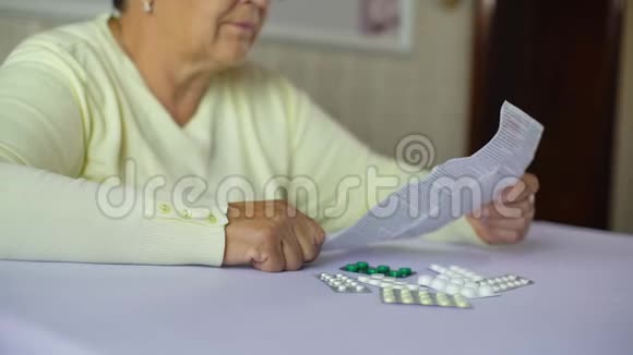 老年妇女在家坐在餐桌前阅读处方药信息单视频的预览图