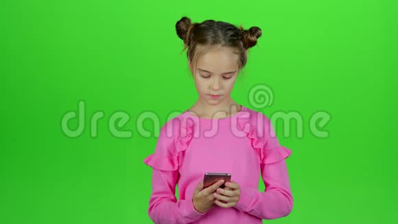 孩子正在和她妈妈打电话绿色屏幕慢动作视频的预览图