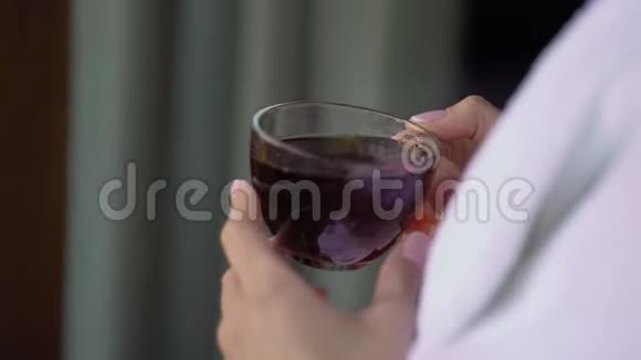 年轻女子早上从杯子里喝茶家庭早餐视频的预览图