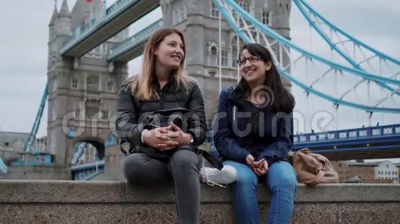 两个朋友坐在伦敦塔桥的墙上视频的预览图