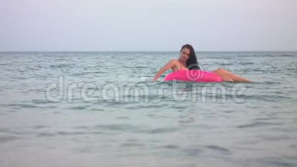 一个女人用粉红色的圆圈在海里洗澡视频的预览图