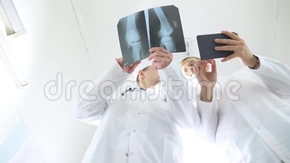 男性医务人员使用平板电脑同时相互咨询患者的x射线图像住院医务人员视频的预览图