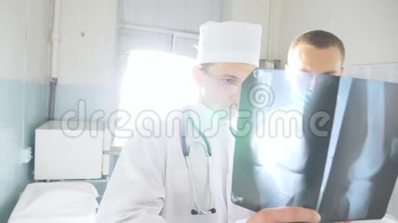 男性医务人员在看x射线图像时互相咨询医务人员在医院检查x射线指纹二视频的预览图