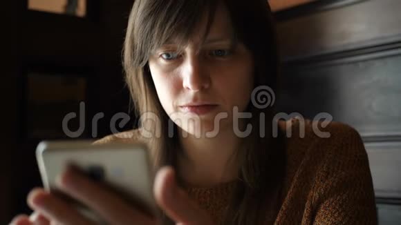 咖啡馆里拿着智能手机的女孩视频的预览图