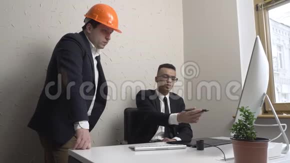 两个年轻的商人建筑师讨论这个项目看看办公室里的班长建设者工程师概念视频的预览图