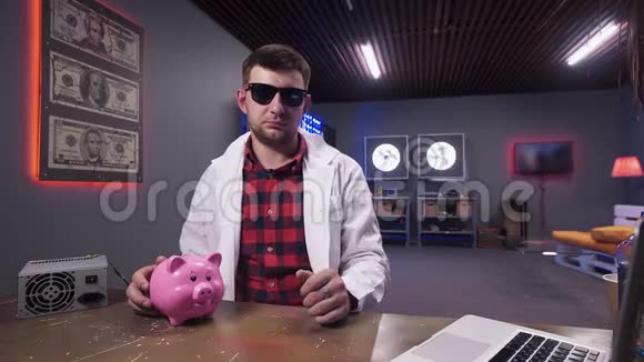 戴墨镜和实验室外套的帅哥说桌子上有猪和笔记本电脑视频的预览图