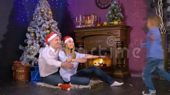 圣诞树下三个人组成的欢乐家庭幸福的家庭观念高清视频的预览图