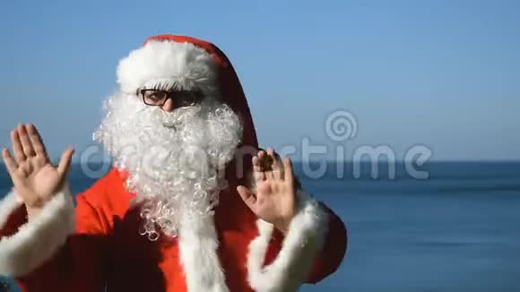 一个穿着圣诞老人服装的人正在海滨跳舞旅行和度假视频的预览图