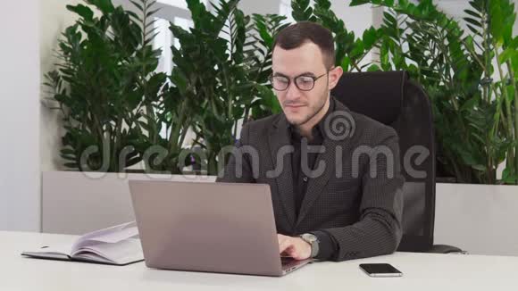 穿西装的年轻商人在手提电脑上工作视频的预览图