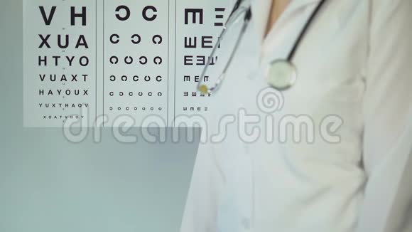 女性眼科医生用小字母指着桌子检查病人的视力视频的预览图