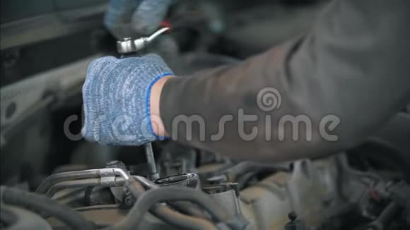 戴手套的机械师用扳手拆卸汽车视频的预览图