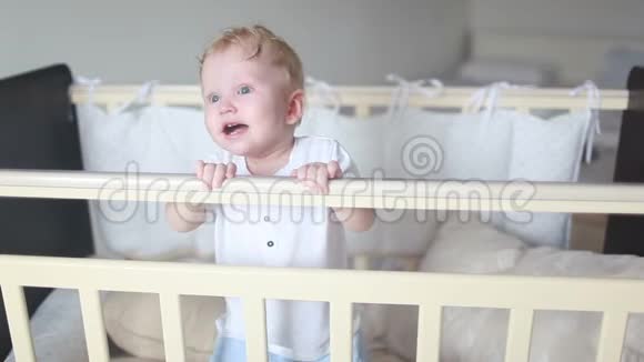 可爱的笑宝宝站在白色的圆床上视频的预览图