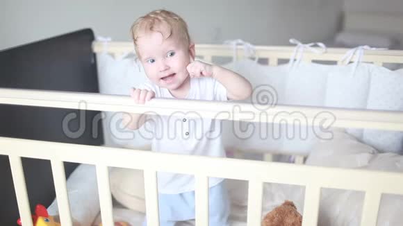 可爱的笑宝宝站在白色的圆床上视频的预览图