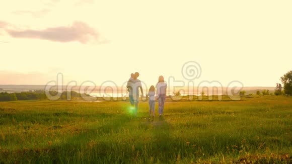 快乐的年轻家庭有两个孩子在夏天的田野上奔跑健康的母亲父亲和儿童享受大自然视频的预览图