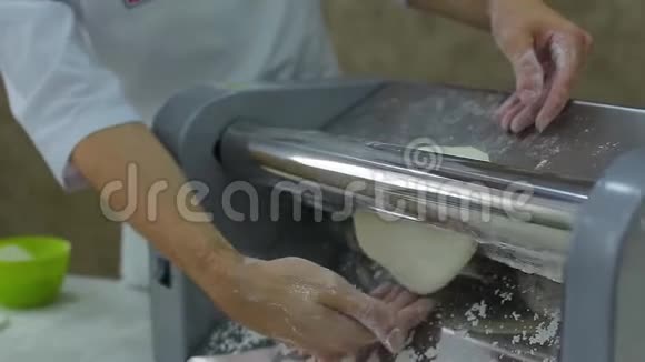 在白色衣服里用机器擀面团把厨师的双手紧紧地握起来视频的预览图