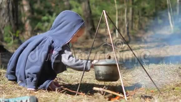 一个小女孩在篝火上扔木头独立勤奋视频的预览图