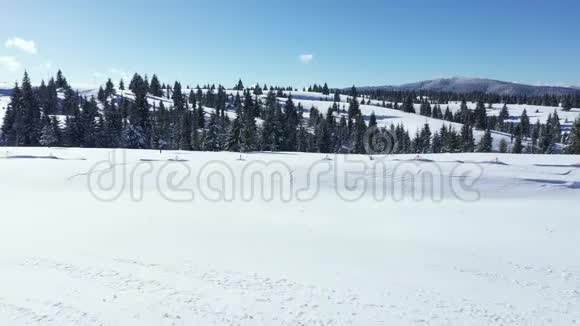 在阳光明媚的一天空中无人机4k可以看到覆盖着雪的山脉视频的预览图