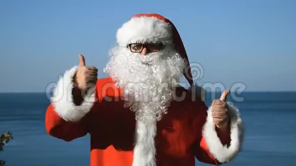 一个穿着圣诞老人服装的人正在海滨跳舞旅行和度假视频的预览图