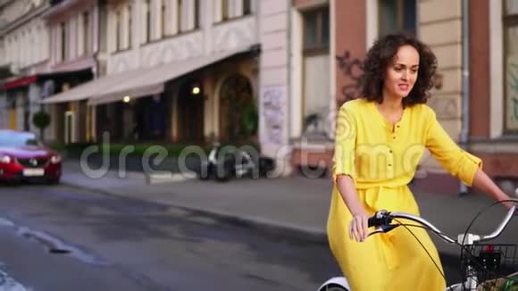 美丽的女人骑着一辆城市自行车带着篮子和鲜花在市中心与人交谈Stadicam视频的预览图